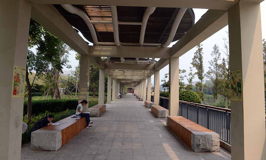 逛公園的市民在濱河長廊小憩