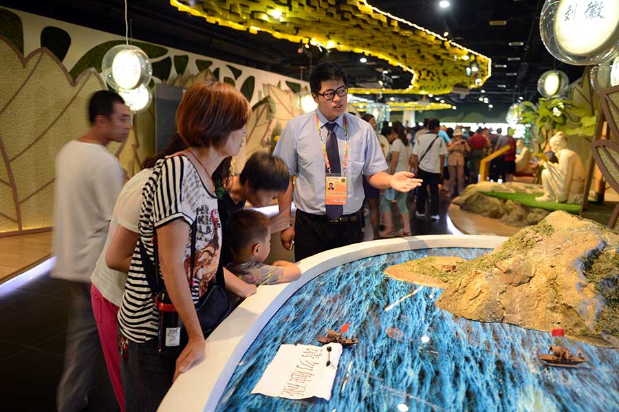 志愿者張國華在主題館B區(qū)引導(dǎo)游客了解古代科技知識