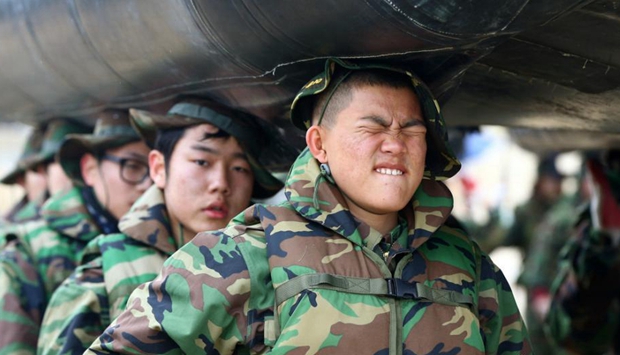 韩国军队举办冬令营 少男少女头顶橡皮艇