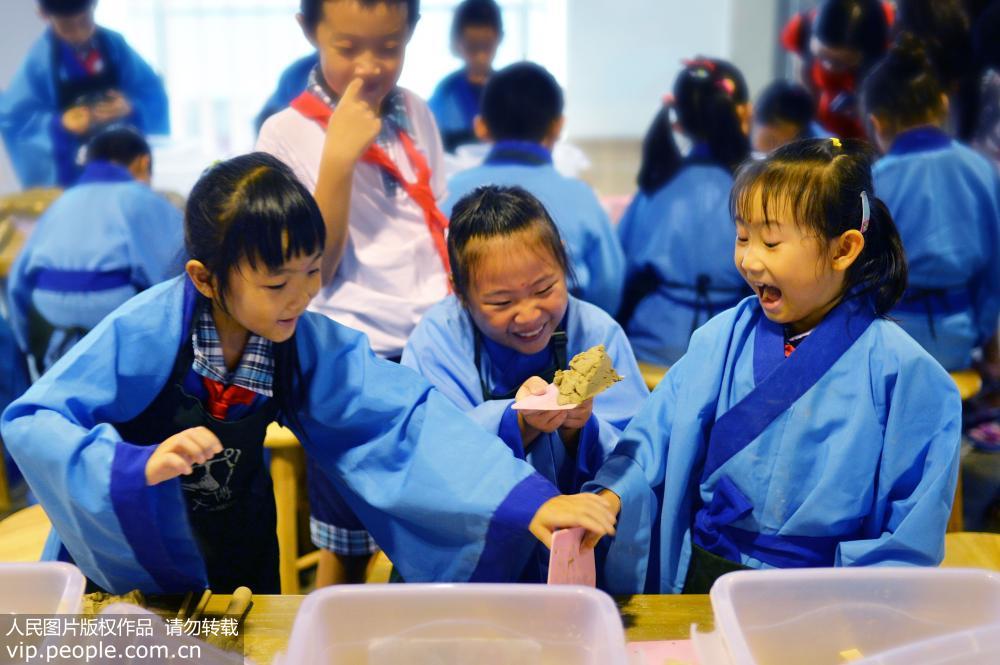 8月28日，青島市同安路小學(xué)一年級新生在漢畫像磚博物館老師的指導(dǎo)下學(xué)習(xí)制作漢畫像磚。