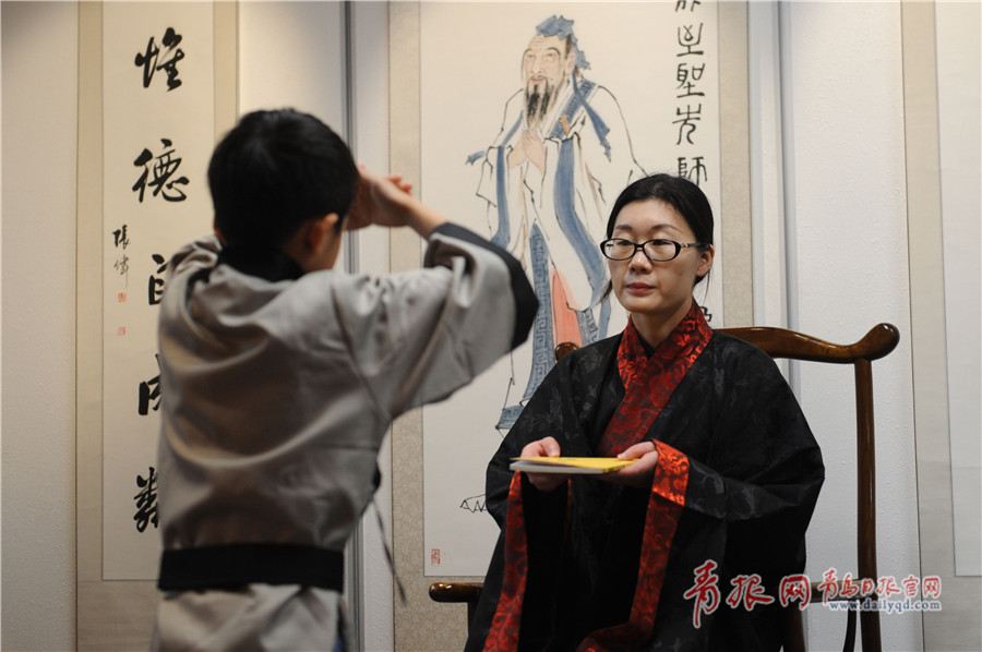青岛传统文化进社区活动演示的儿童国学礼仪—老师向学子授书.