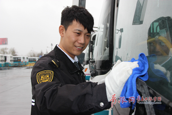 90后驾驶员李昊正在对车辆进行清洁□青岛日报/青报网记者 周建亮