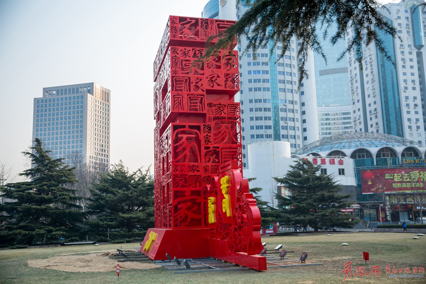 红色的雕塑的侧面的"书法"元素.不少市民在雕塑前驻足拍照.