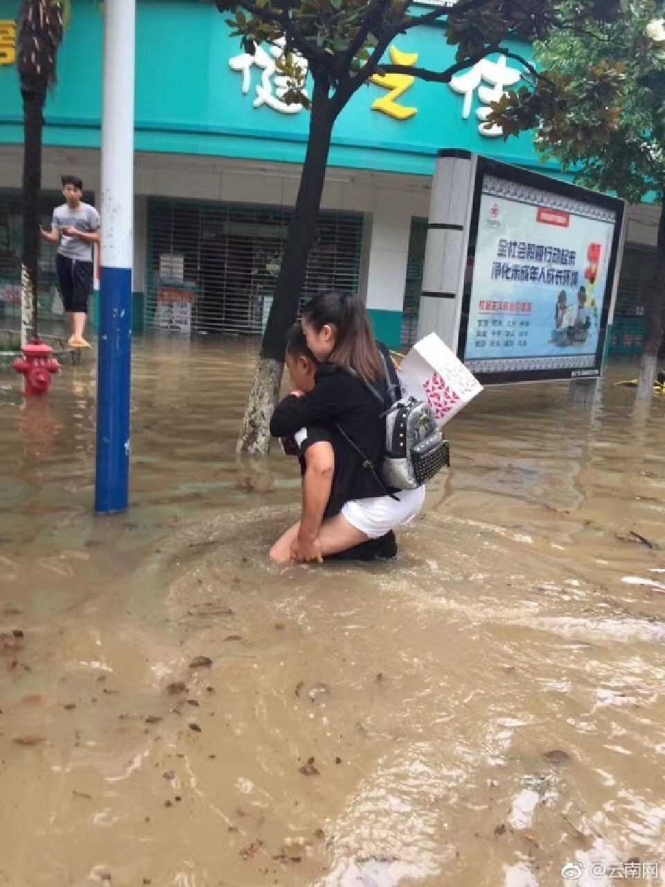 昆明暴雨暖心小伙义务背人摆渡