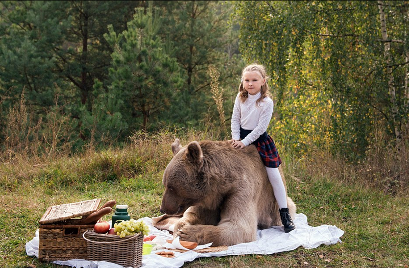 图为stepan满足的卧在食物旁边,小女孩骑在她的身上.