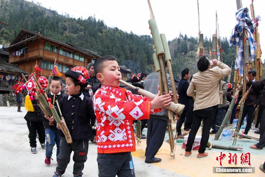 2月22日,苗族小男孩在踩歌堂上吹奏芦笙.